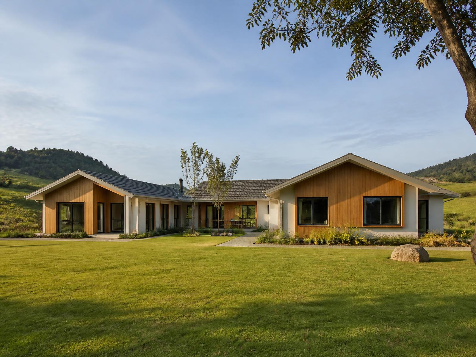 Casa modular Abrigo Family 60 com revestimento em madeira e amplo gramado